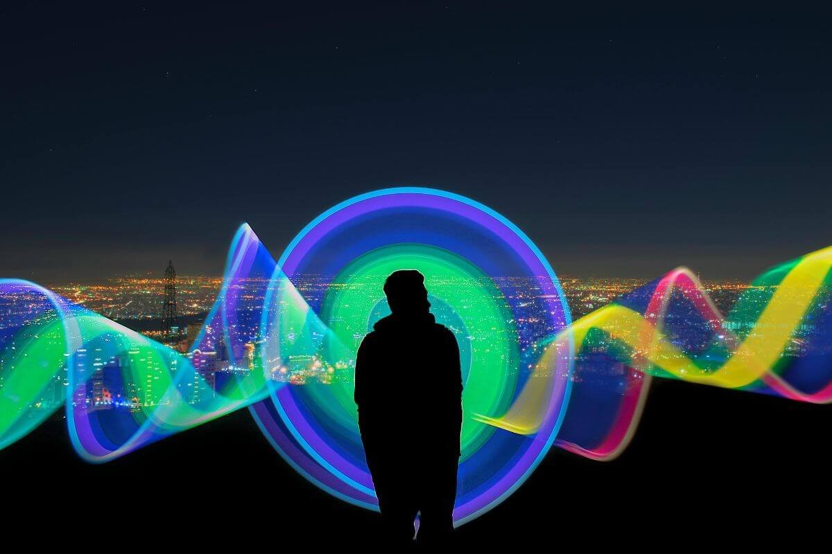 Human silhouette with colorful light waves representing the science and psychology of money frequency