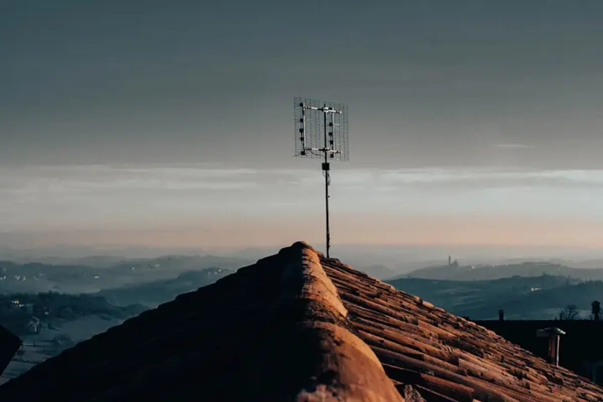 A minimalist antenna silhouette against a hazy horizon, symbolizing the act of tuning into a higher frequency and energy alignment during an awakening.